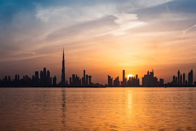 Budlings, skyscrapers, and the water during sunset in Dubai.